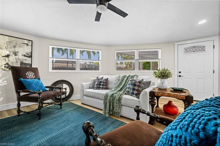 Living room featuring wood finished floors, healthy amount of natural light, and ceiling fan