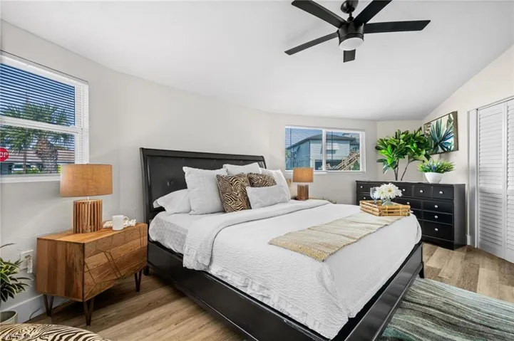 Bedroom with a closet, light wood-style floors, vaulted ceiling, and a ceiling fan