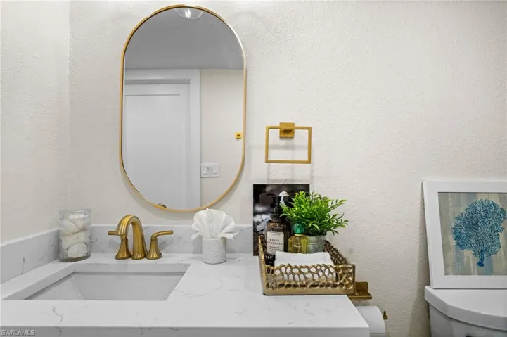 Half bathroom featuring a textured wall and vanity