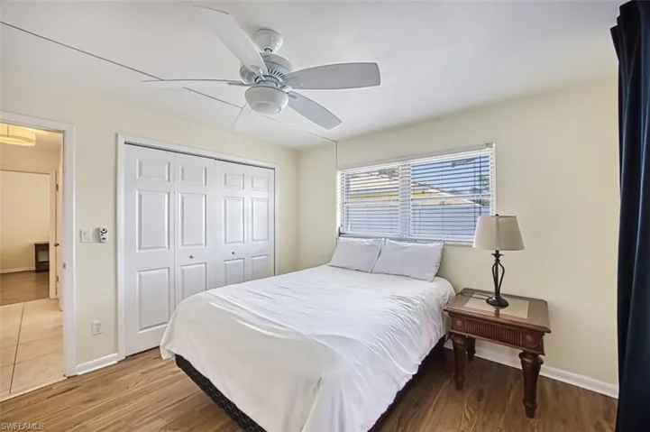 Bedroom with ceiling fan, a closet, and wood-type flooring