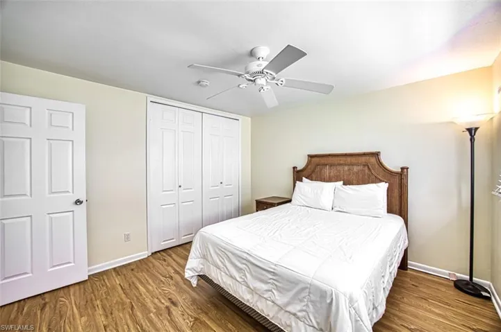 Bedroom with a closet, ceiling fan, and dark hardwood / wood-style flooring