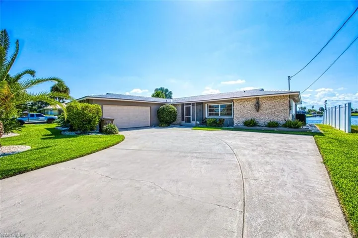 Ranch-style home with a garage and a front lawn
