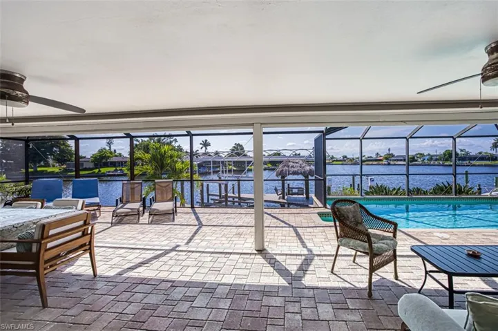 Sunroom / solarium with ceiling fan and a water view