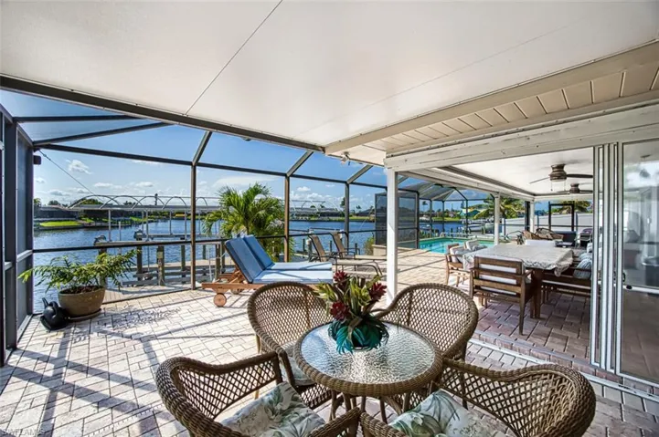 Sunroom / solarium featuring ceiling fan and a water view