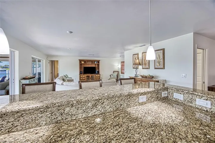 Kitchen featuring decorative light fixtures and stone countertops