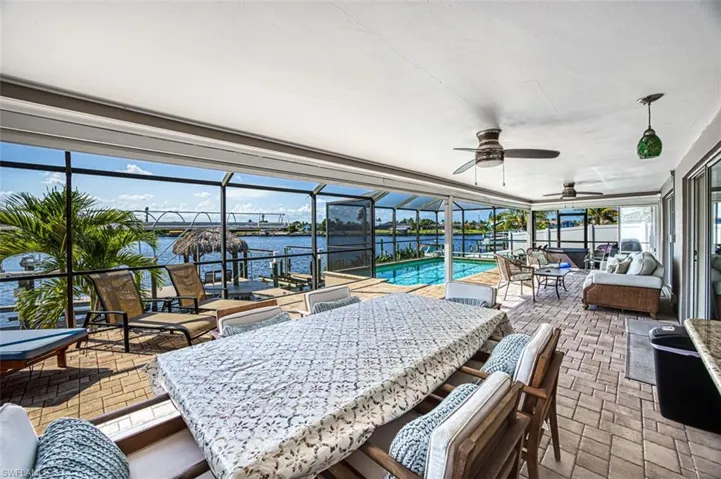 Sunroom / solarium featuring a water view and ceiling fan