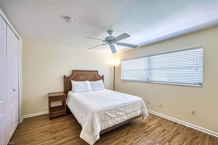 Bedroom featuring dark wood-type flooring, a closet, and ceiling fan