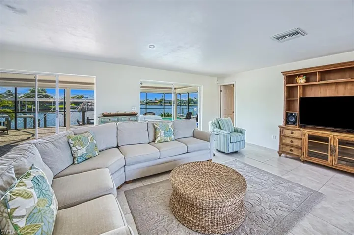 Living room with light tile floors, a healthy amount of sunlight, and a water view