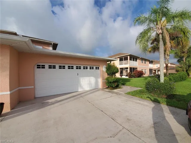 View of front of house featuring stucco siding, concrete driveway, and a front lawn