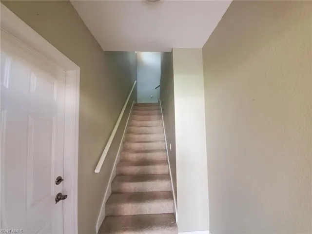 Staircase with carpet floors and baseboards