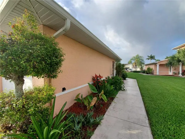 View of property exterior with a lawn and stucco siding