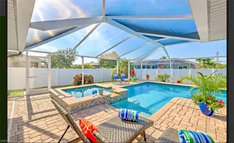 Integrated pool / hot tub featuring a sunroom, a patio, and glass enclosure
