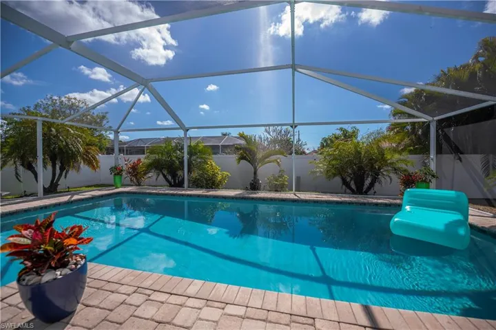 View of swimming pool featuring a sunroom, glass enclosure, and a fenced backyard
