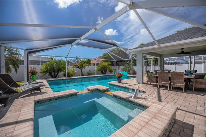 Integrated pool / spa with a fenced backyard, a patio area, a sunroom, glass enclosure, and outdoor dining area