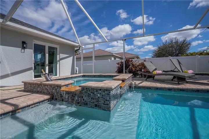 Integrated pool / hot tub featuring a sunroom, a lanai, and a patio