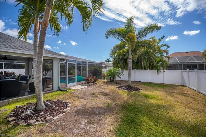 Fenced backyard with a sunroom, glass enclosure, and an outdoor hangout area