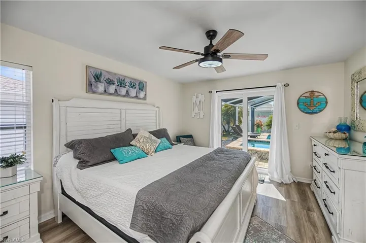 Bedroom with access to outside, dark wood-style floors, and a ceiling fan