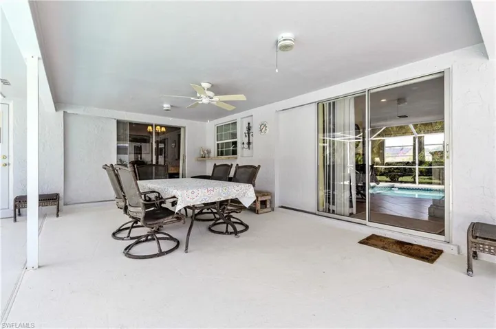 Dining space featuring a textured wall, a ceiling fan, and a sunroom