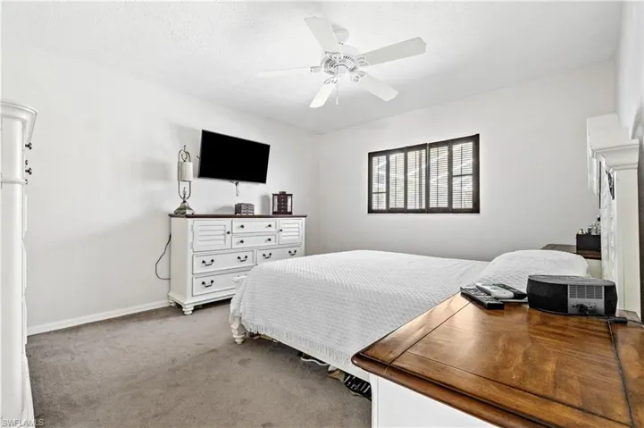 Bedroom featuring light colored carpet, ceiling fan, and a textured ceiling