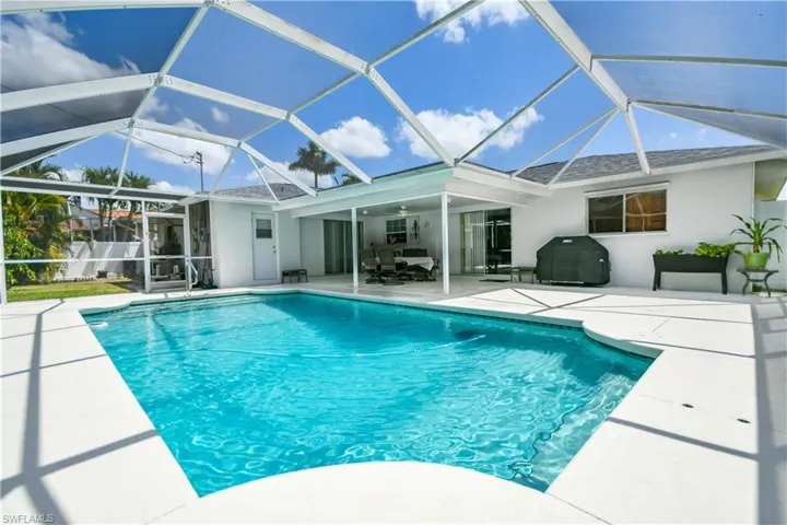 Outdoor pool with a sunroom, a patio, a lanai, and grilling area