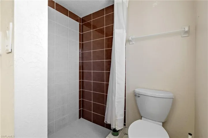 Bathroom featuring a shower stall and a textured ceiling