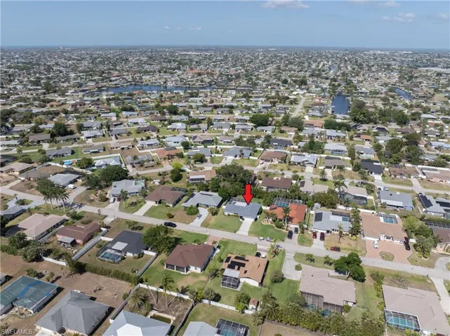 Aerial view of property and surrounding area featuring nearby suburban area