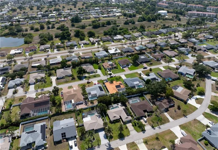 Aerial view of property and surrounding area featuring nearby suburban area
