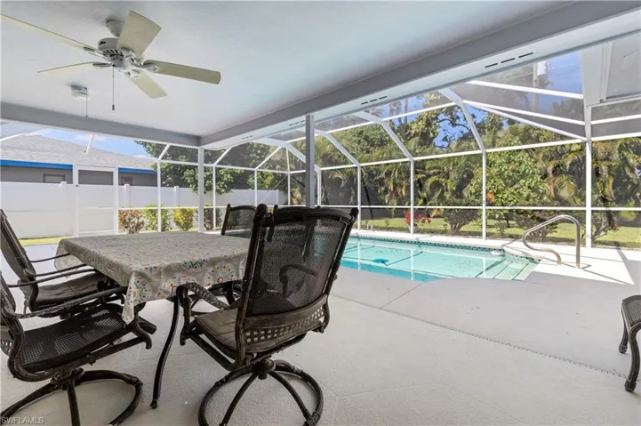 View of pool featuring glass enclosure, a fenced backyard, a sunroom, and a patio