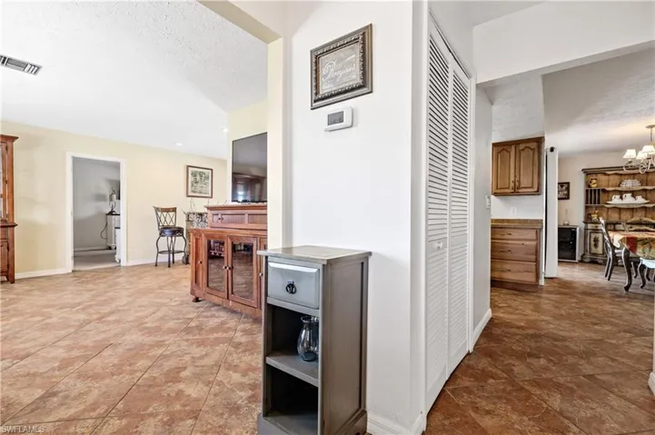 Hallway featuring a chandelier, beverage cooler, and a textured ceiling