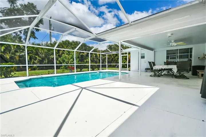 Swimming pool with a patio, glass enclosure, a sunroom, and outdoor dining area