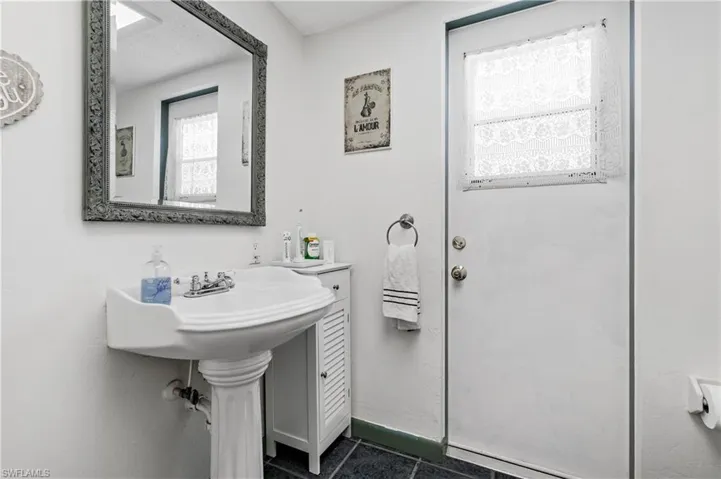 Bathroom with baseboards and dark tile patterned flooring