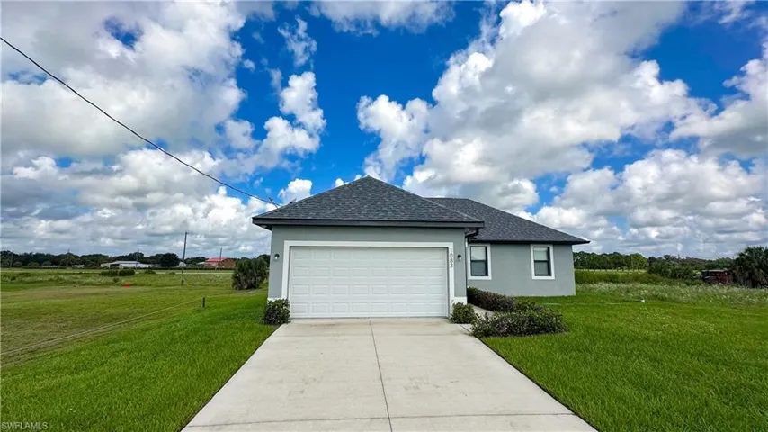 Single-story residence featuring a gray exterior, dark shingle roof, and a white panel garage door