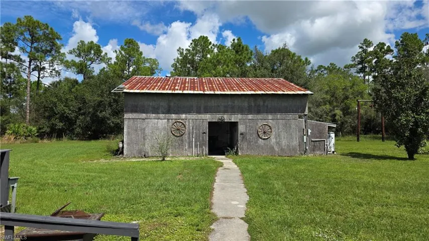 Barn structure with a metal roof, wood siding, and decorative wagon wheels