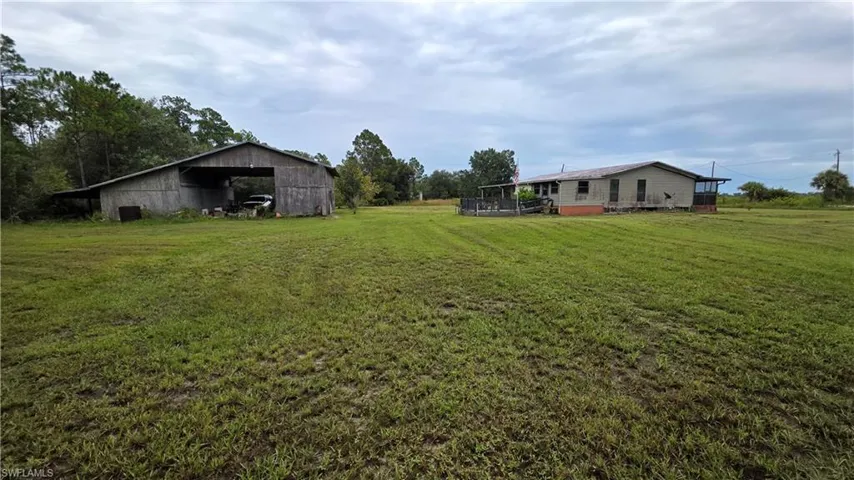 Expansive grass lawn with a barn structure and single-story residence