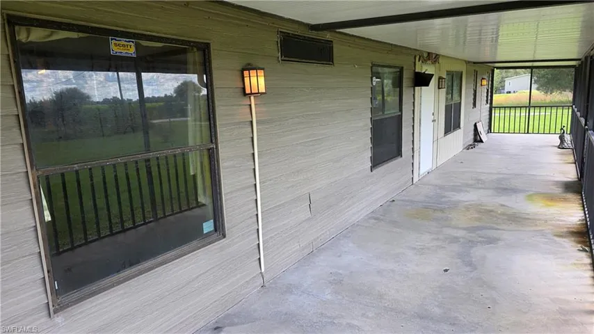 Screened porch with concrete flooring and light-toned horizontal siding
