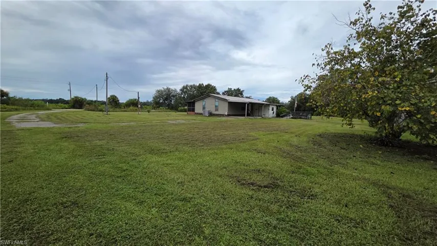Single-story residence with a covered porch situated on a spacious grassy lot