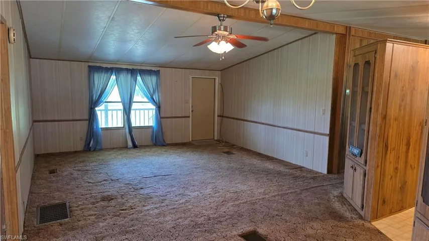 Expansive living area featuring paneling walls and a built-in display cabinet