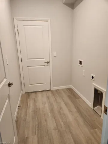 Laundry room with light wood-type flooring, washer hookup, and hookup for an electric dryer