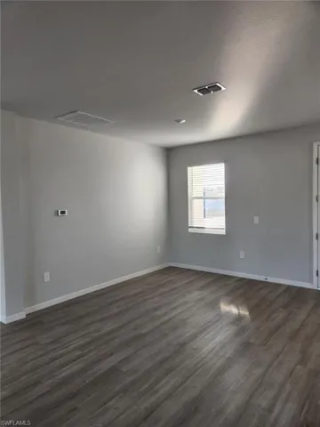 Spare room featuring dark wood-style floors