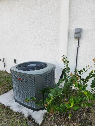 Exterior view of stucco siding and a cooling unit