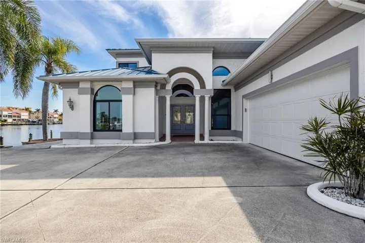 View of front of property featuring a garage, a water view, and french doors