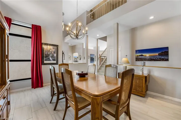 Dining area featuring a high ceiling, light wood-type flooring, and an inviting chandelier