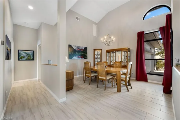 Dining area featuring high vaulted ceiling, a chandelier, and light wood-type flooring