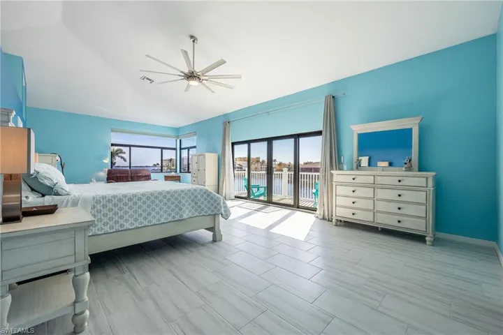 Bedroom with lofted ceiling, access to exterior, and ceiling fan
