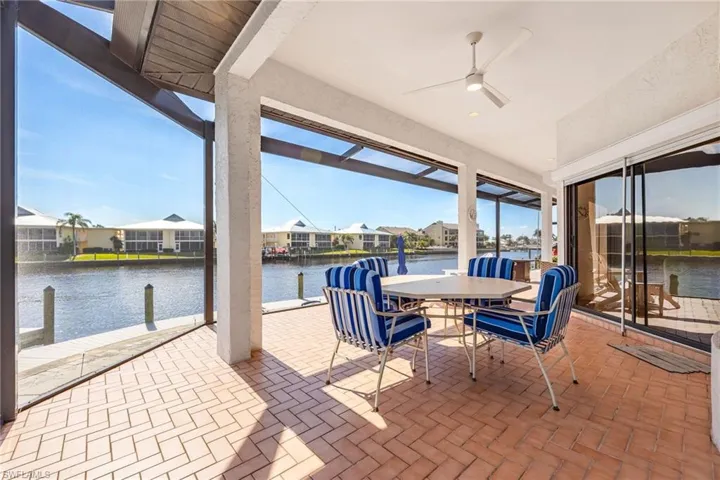 View of patio featuring a water view and ceiling fan