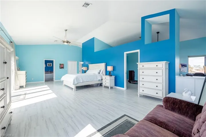 Bedroom with ceiling fan, lofted ceiling, and light hardwood / wood-style floors