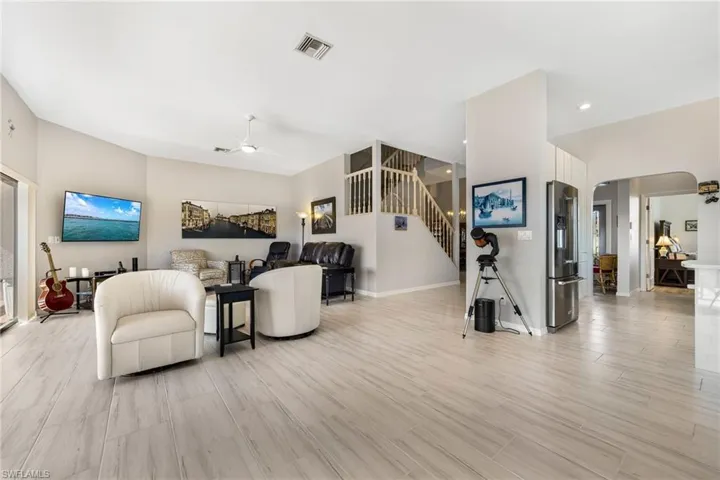 Living room with ceiling fan and light hardwood / wood-style flooring