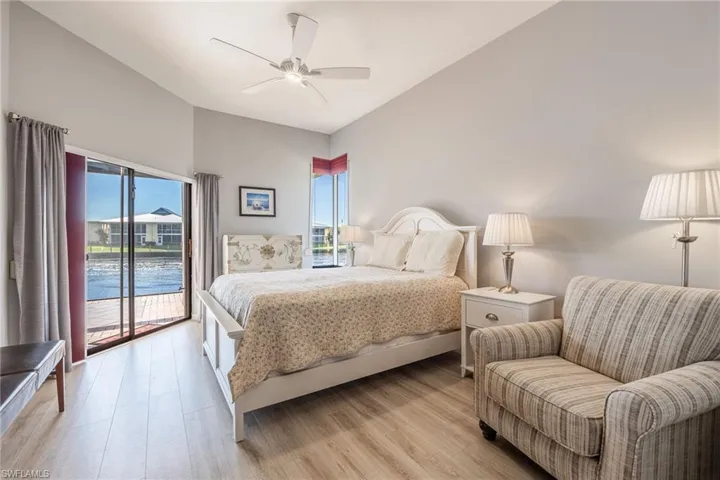 Bedroom with ceiling fan, a water view, access to outside, and light wood-type flooring