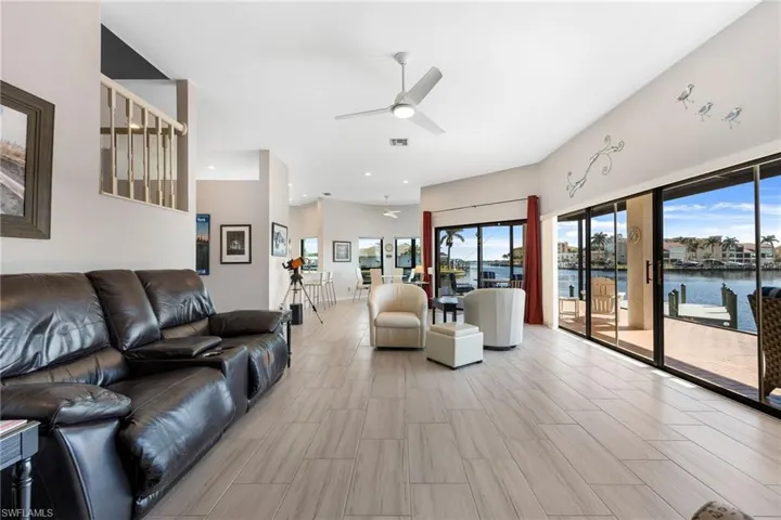 Living room featuring ceiling fan and a water view