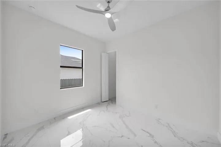 Unfurnished room featuring ceiling fan and light tile floors